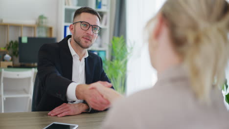 smiling real estate agent shakes hands during negotiations