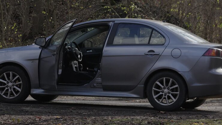 Voiture berline vide avec les feux de détresse clignotants, abandonnée après un accident de voiture ou un acte de vandalisme criminel