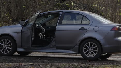 automóvil de saloon vacío con luces de advertencia de peligro intermitentes abandonado después de un accidente automovilístico o vandalismo criminal