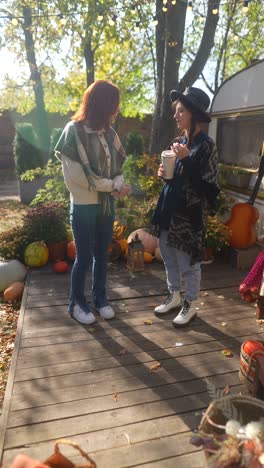 two friends enjoying a coffee in an autumn garden