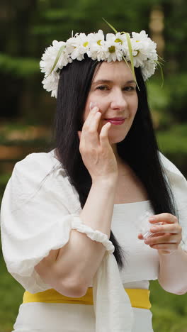 feliz 40 años de edad madura mujer de mediana edad aplicando la piel facial crema hidratante tratamiento de belleza