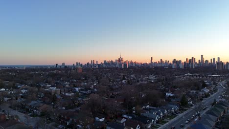 Disparo-De-Un-Dron-De-4.000-Metros-Elevándose-En-Un-Barrio-Del-Este-De-York-Al-Atardecer-Mostrando-El-Centro-De-Toronto-A-Lo-Lejos