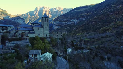 paisaje montañoso escénico con casas antiguas e iglesia al atardecer