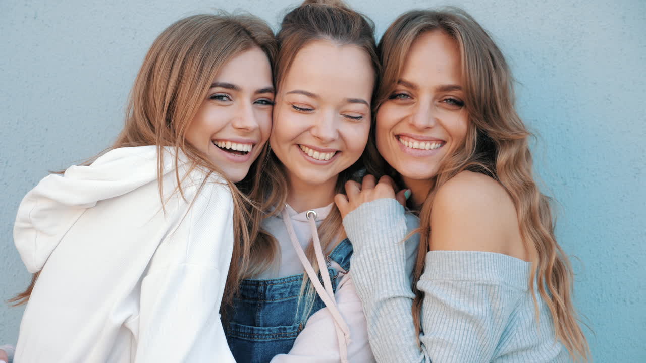 세 명의 젊은 여성 친구들이 서로의 회사를 즐기고 있습니다.