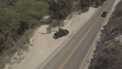 toma de seguimiento de un todoterreno negro saliendo y conduciendo por la carretera