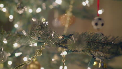 luces centelleantes y adornos en un árbol de navidad artificial plateado