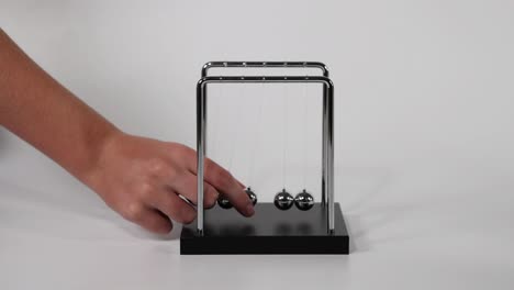 la mano inicia el movimiento en la cuna de newton.