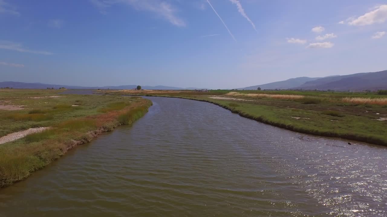 antena: un delta de un río con un puente de carretera que lo atraviesa y algunos edificios agrícolas