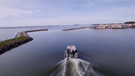 fishing boat speeding up to the sea, leaving harbour port in boat, to the horizon, fishfarm, fishing farm, oyster farm