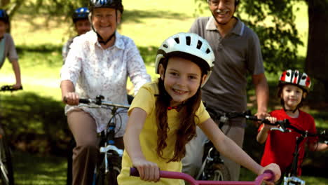familia feliz montando bicicletas en el parque