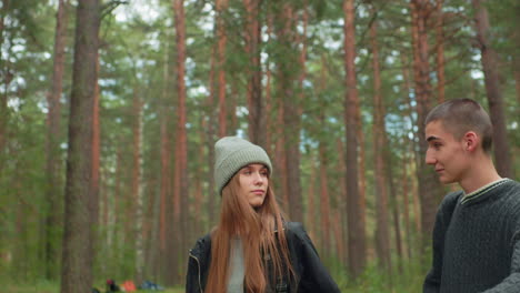 two young researchers walking through forest stop to take rest, surrounded by tall trees and lush greenery, appearing thoughtful and calm while enjoying tranquil atmosphere of natural environment