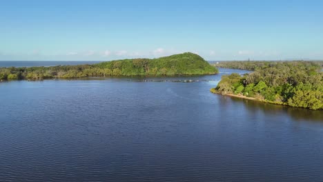 drone captures serene river and lush islands under clear blue skies, showcasing natural beauty and tranquility
