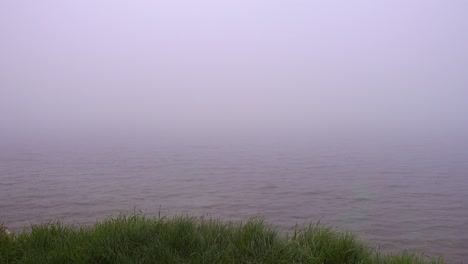 una densa niebla sobre la superficie del agua tranquila.