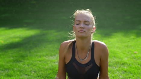 woman with prosthetic leg doing yoga in park. girl stretching body outdoors