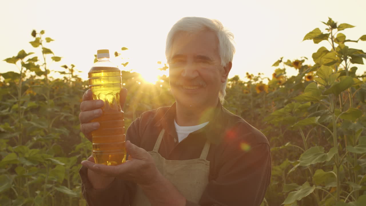 Portrait Of Farmer With Bottle Of Sunflower Oil