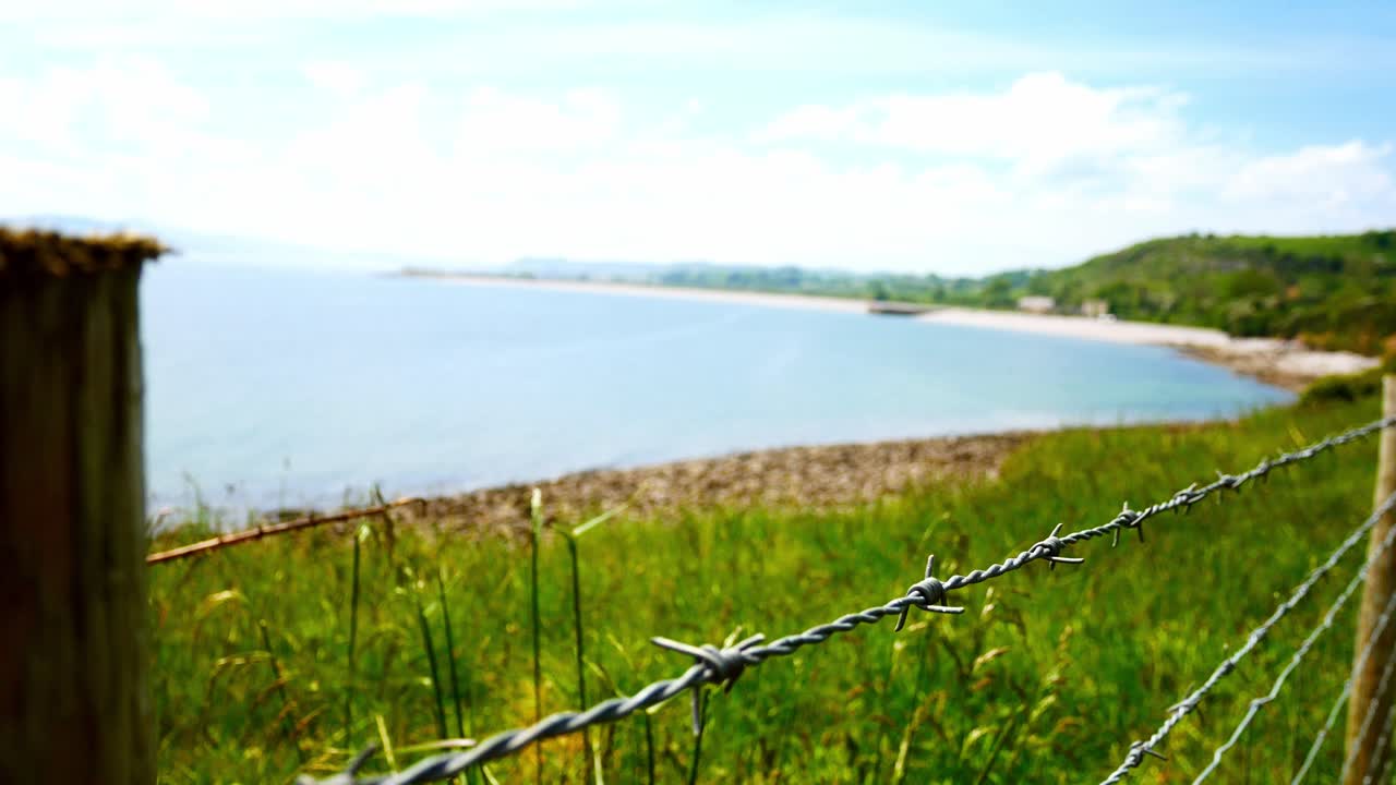límite de alambre de púas con vistas a la calma acantilado costa campo frente al mar senderismo paisaje seguir adelante