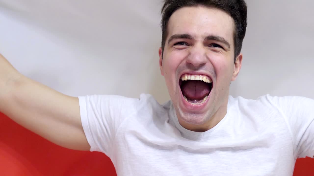 폴란드 젊은이가 느린 동작으로 폴란드의 발을 들고 축하합니다.