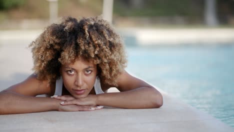 young woman sunbathing near swimming pool
