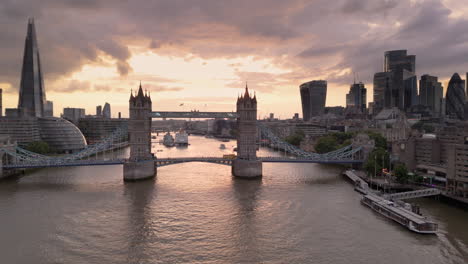 Antenne-In-Richtung-London-Tower-Bridge-über-Die-Themse-Mit-Skyline-Der-Stadt-Gegen-Sonnenuntergang