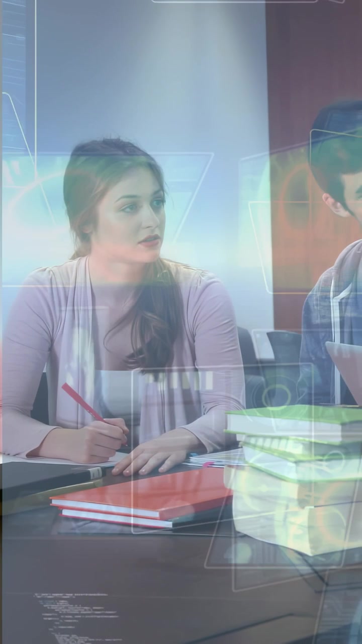 Vertical video: Writing woman in cardigan listening during peer talk at table, holding red pen, HUD