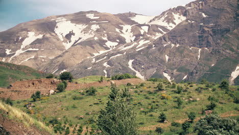 the end of the winter the beginning of the spring the remains of snow on the mountain peaks grass and trees