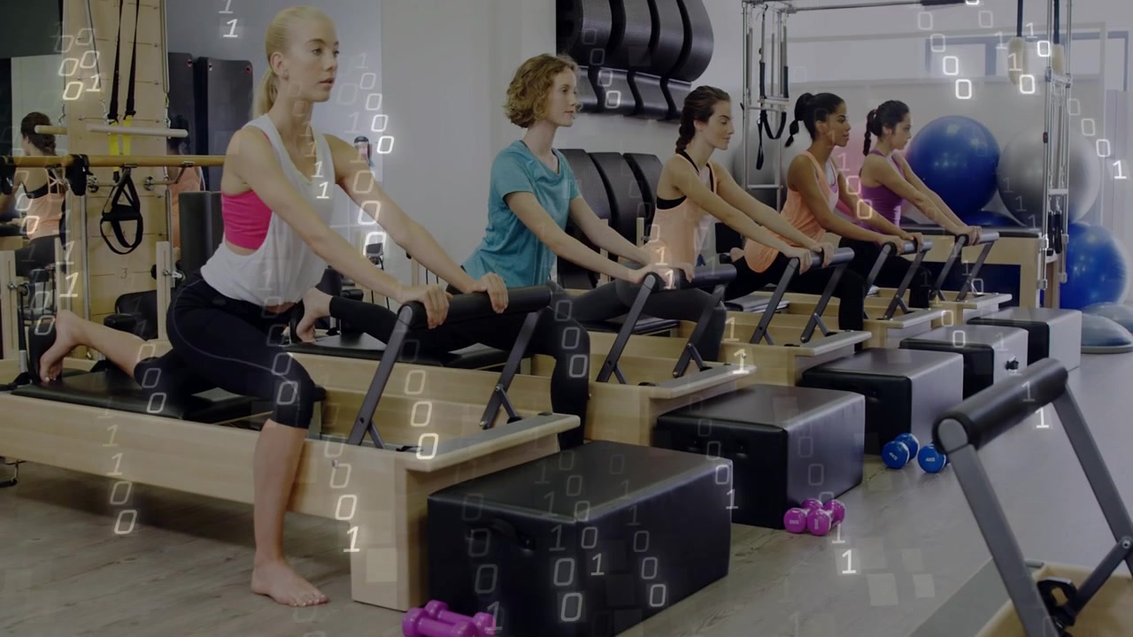 Reformer üzerinde diz çökmüş beş kadın, tutacakları kavrayarak Pilates için senkronize lunge hareketlerine başlıyor.