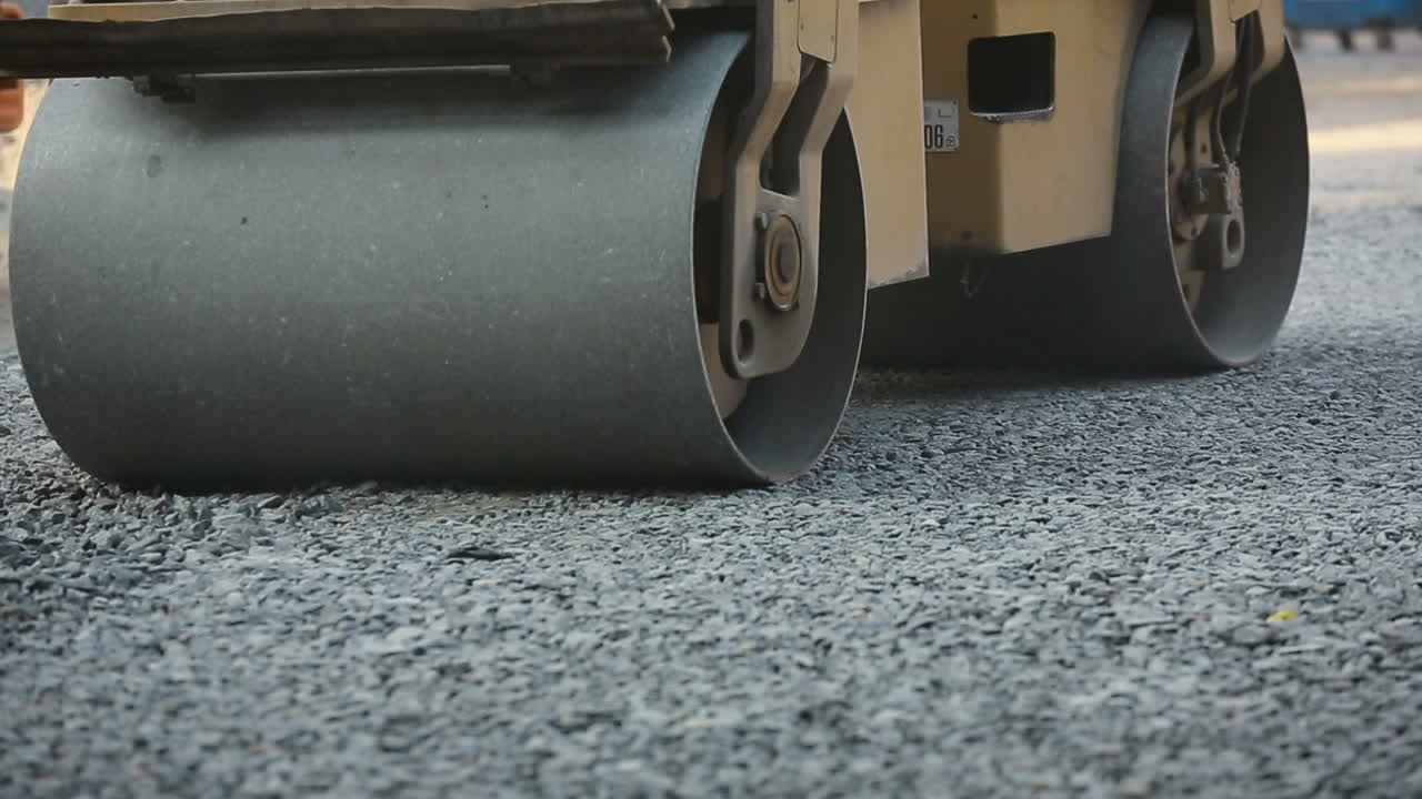 Road Roller Working On A Gravel. Road roller laying gravel during road construction