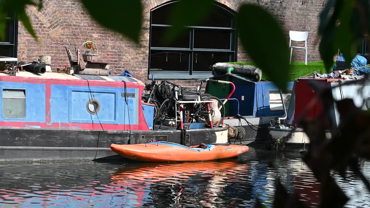 Men walking past boats on Regents Canal