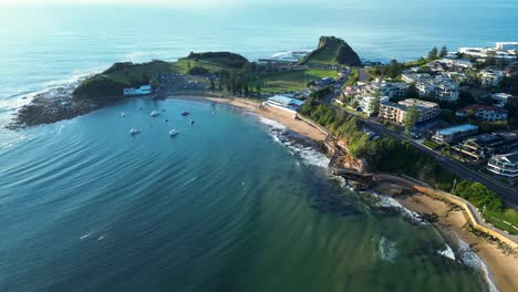drone aerial view of terrigal town suburbs with residential and commercial buildings on coastline headland sandy ocean beach bay with boats the haven skillion central coast australia travel holidays