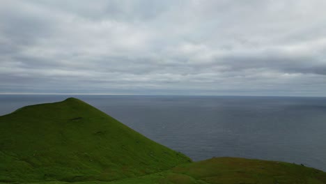 Antena-Hacia-Arriba-Que-Revela-Una-Exuberante-Y-Verde-Pradera-Montañosa-De-La-Isla-Kalsoy-Cerca-Del-Océano