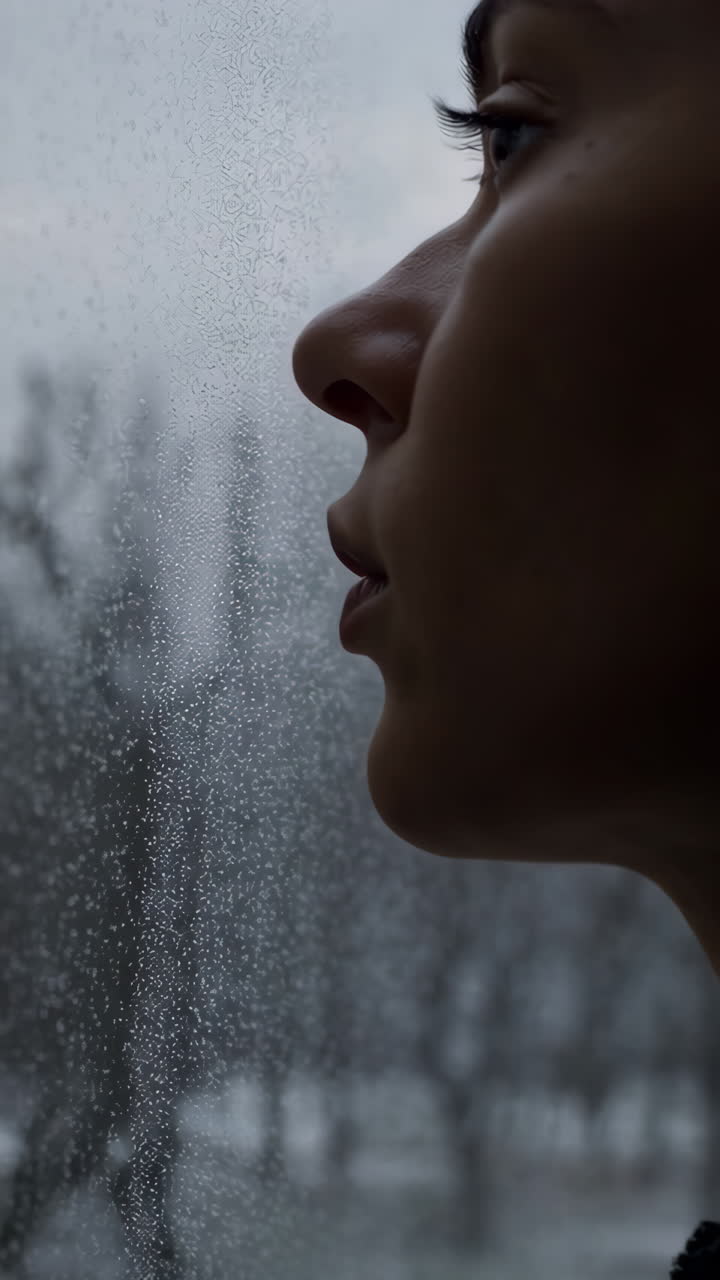 Pessoa Olhando pela Janela em um Dia Frio de Inverno