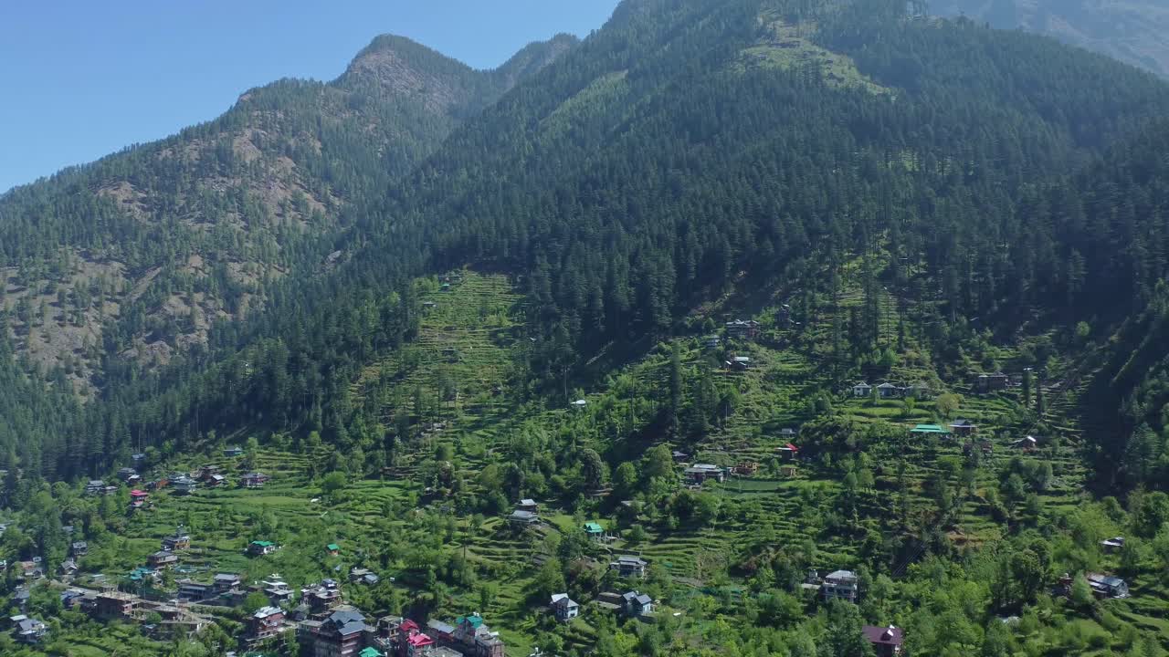 Aerial view short of Jibhi Himachal Pradesh in India. Houses and trees in the mountainous area. Faguli festival is one of the biggest festival in Jibhi. The traditional houses here have stone roofs.