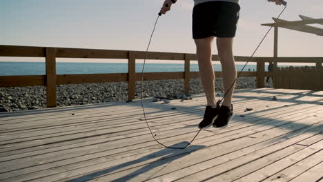 hombre saltando la cuerda en el muelle de la playa