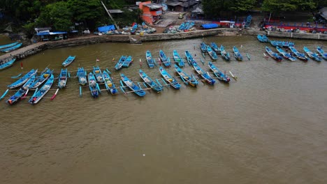 Orbit-drone-shot-of-many-fishermen-boats-anchored-on-the-harbour-when-not-at-sea-looking-for-fish---Baron-Beach,-Yogyakarta,-Indonesia
