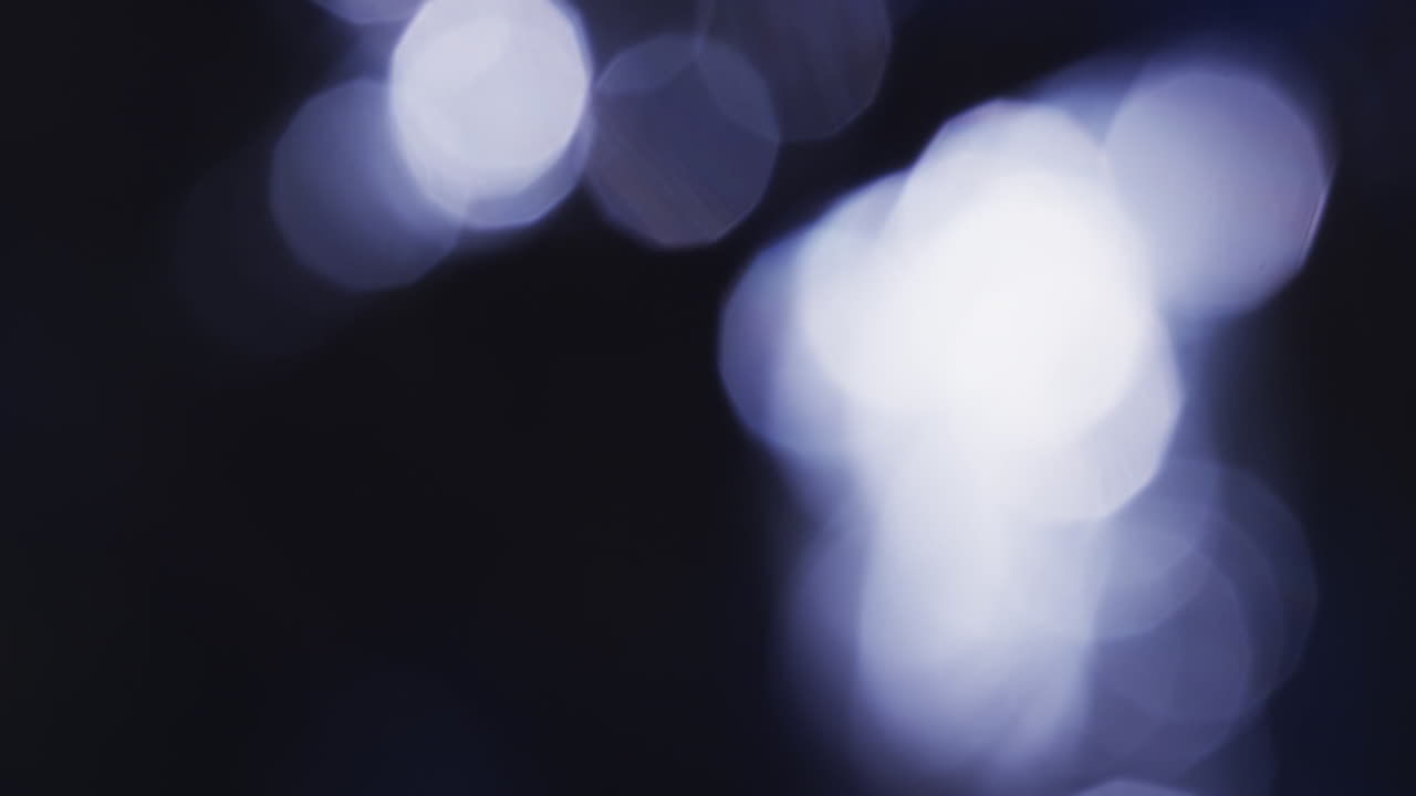 Video di punti luce bokeh bianchi e viola tremolanti con spazio per il testo