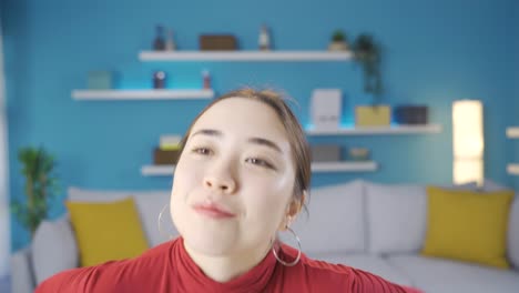 Asian-woman-sitting-alone-at-home-thinking-about-happy-moments-and-smiling.