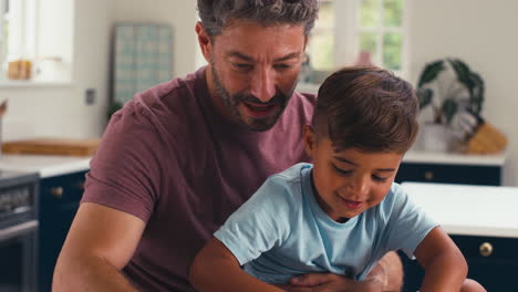 close up de padre maduro en casa en la cocina con el hijo haciendo rompecabezas juntos