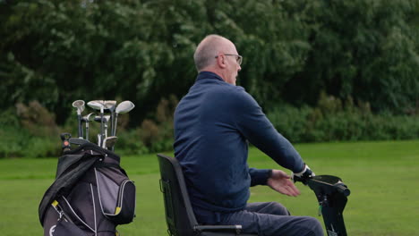 Man on a golf cart with golf clubs