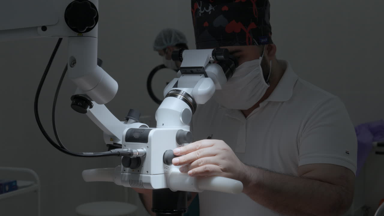 cirujano usando el microscopio médico en la sala de operaciones