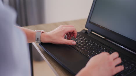 close-up of hands typing on laptop keyboard