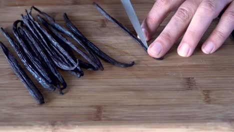 Rebanar-Las-Habas-De-Vainilla-Con-Un-Cuchillo-En-Una-Tabla-De-Cortar-De-Madera,-Cerrar