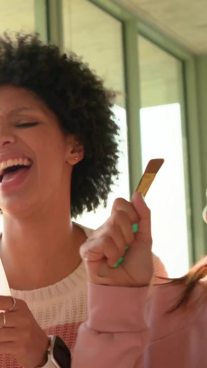 Donna riccia che inizia a cantare con gli amici in una spazzola vicino a una finestra soleggiata, creando note animate per la musica