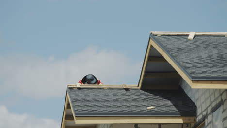 the builder is working on the roof of the house - laying shingles