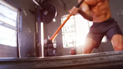 hombre haciendo un ejercicio de entrenamiento con martillo