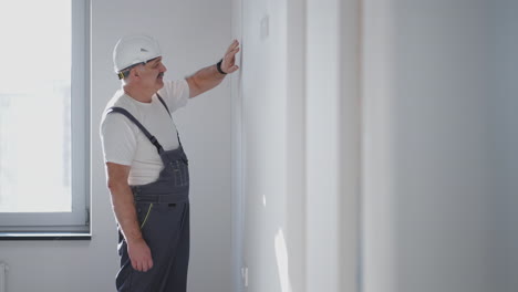 The-electrician-turns-on-the-installed-lighting-in-the-apartment-and-looks-at-the-light