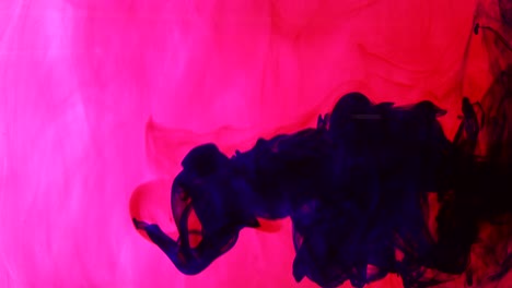 hermosa tinta azul girando en el líquido rojo. fondo de vórtice abstracto