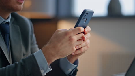 man hands messaging smartphone sitting office closeup. boss holding telephone