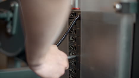 different heaviness metal blocks at gym. man hands changing block in sport club