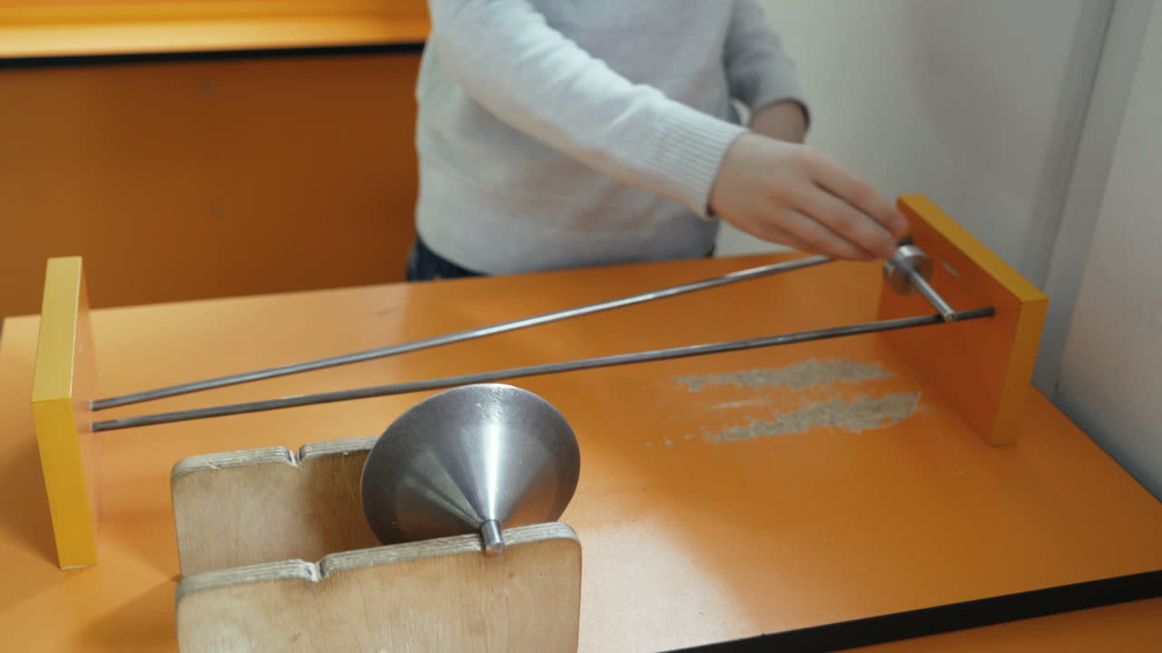 Boy is playing with a metal cone. Museum of entertaining sciences