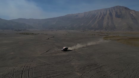 following a car with drone through bromo's lava fields at sunrise, with striking sand rush tire tracks